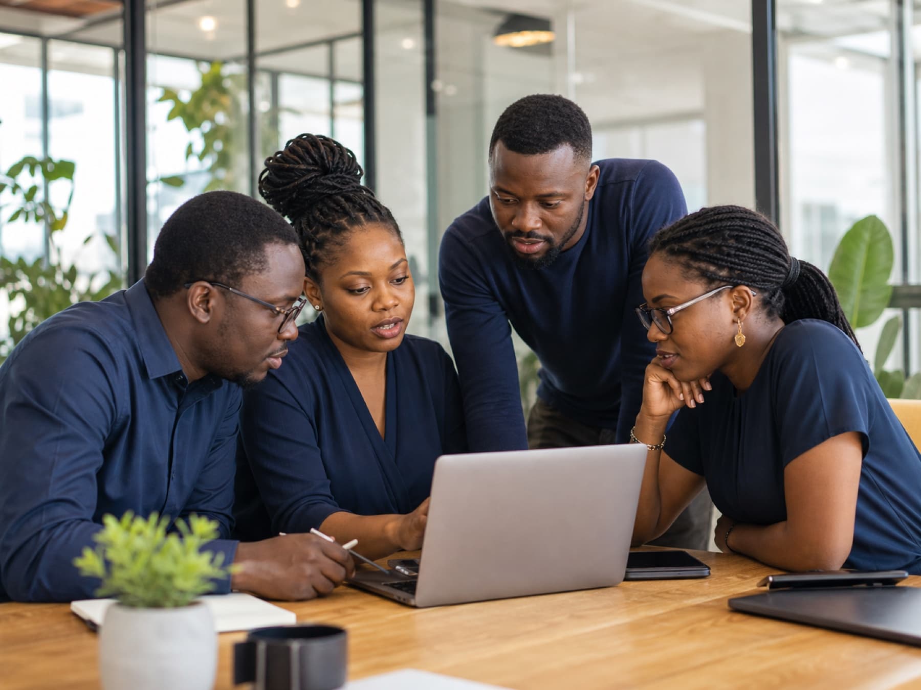 A team of engineers collaborating around a laptop